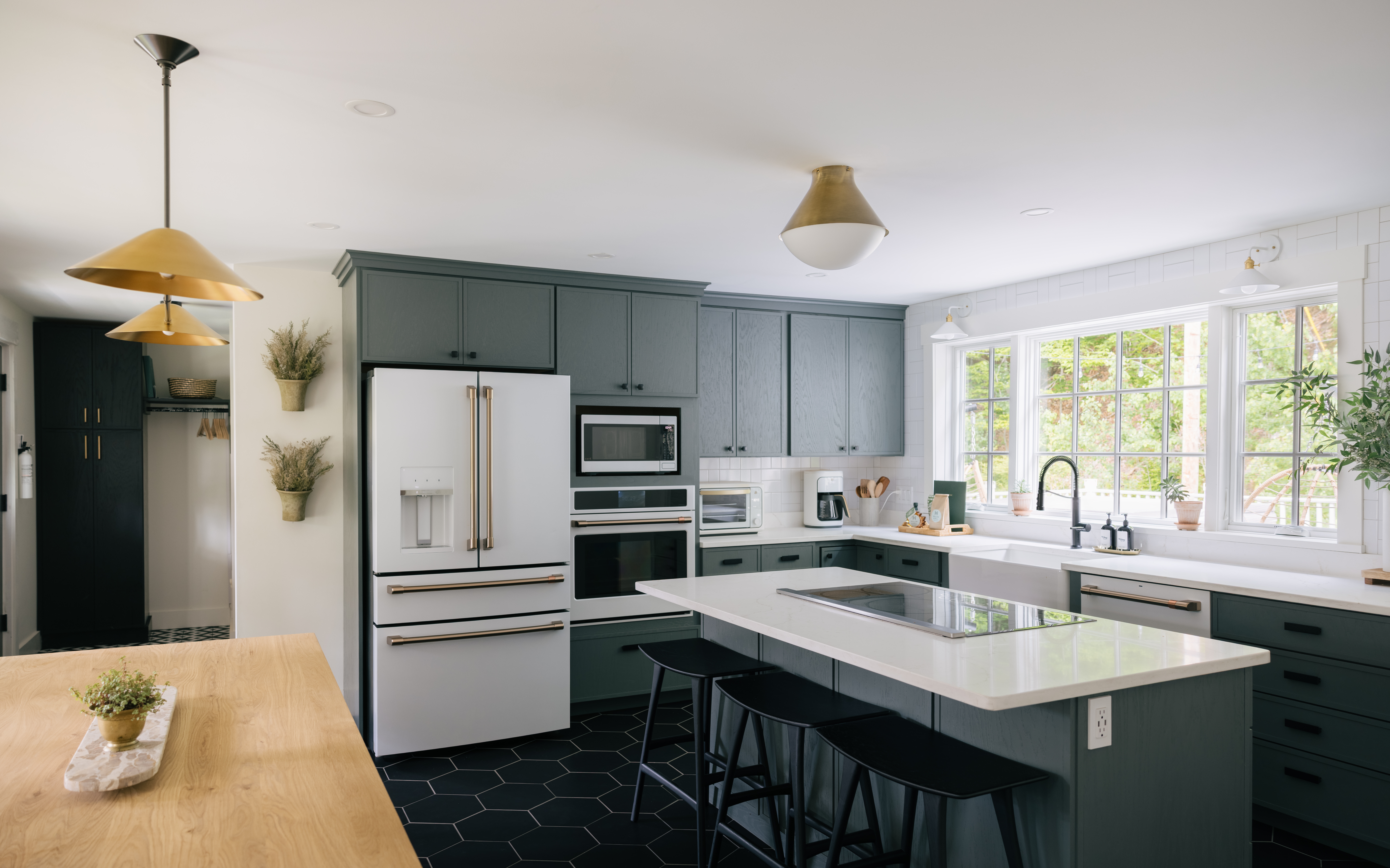 Main house kitchen with large island, modern appliances, and natural light